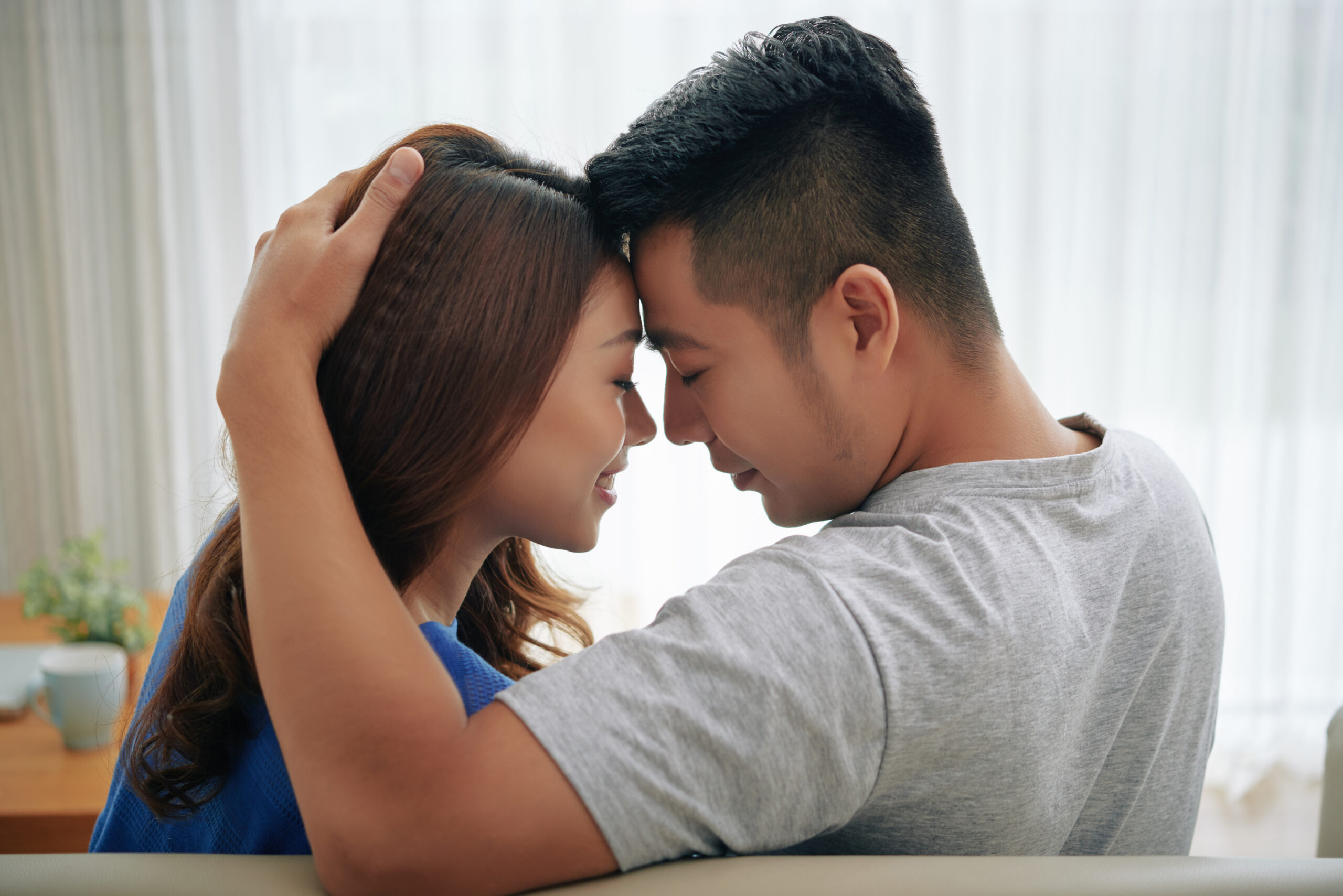 Beautiful close couple in love sitting on couch